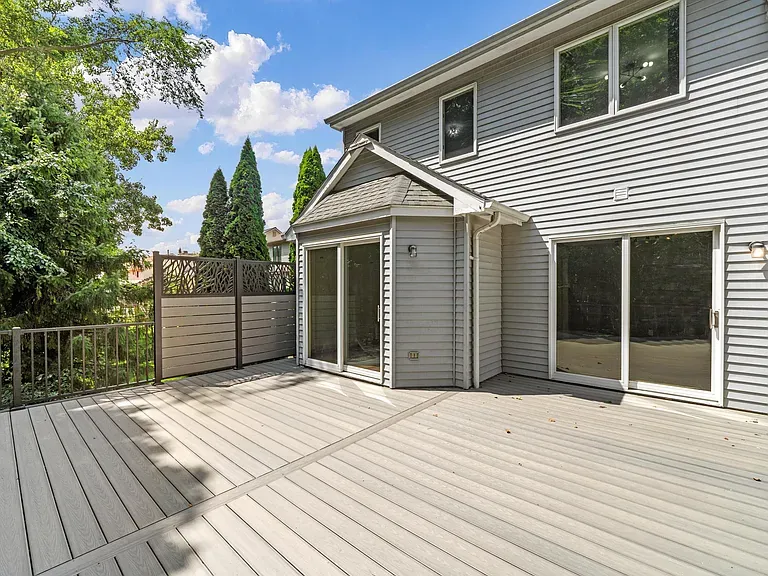 Composite deck connected to home with privacy screen and sliding door access in Ann Arbor Fire Fox subdivision
