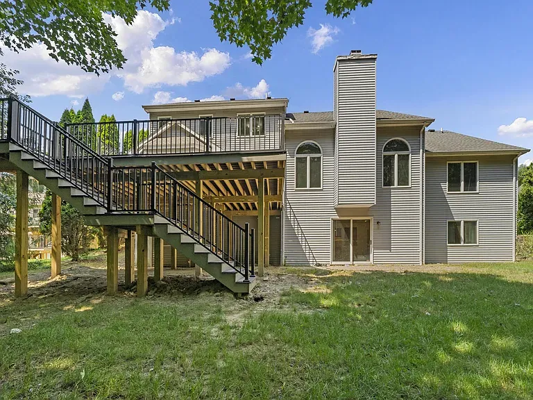 Elevated composite deck with staircase and black aluminum railing at Ann Arbor home in Fire Fox subdivision