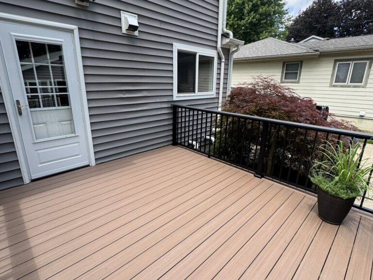 Corner detail of a Deckorators Summit Cliffside composite deck with Trex Signature black aluminum railing and cocktail rail in Historic Downtown Northville.
