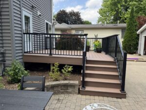 Composite deck renovation completed by Titan Decks in Historic Downtown Northville using Deckorators Summit Cliffside decking and Trex Signature railing.