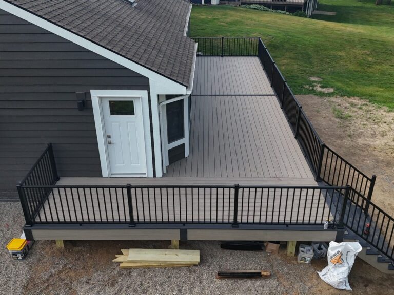 Deckorators Cliffside composite deck with Dark Slate picture frame and black Trex Signature railings in Green Oak Township Michigan