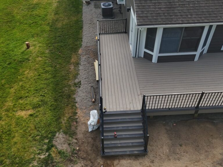 Wide composite deck stairs with Dark Slate accents and black aluminum railings in Green Oak Township