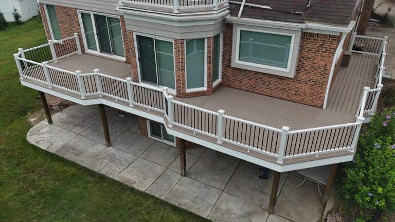 Angled rear view of Cliffside composite decking, AZEK PVC fascia, and white Trex Select railing with black balusters.