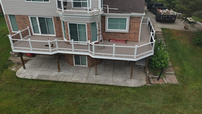 Wide view of the Cliffside composite deck with AZEK PVC fascia and white Trex Select railing with black balusters.